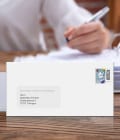 Vorfrankierter Briefumschlag mit Fenster zeigt schöne Briefmarken wie die Brieftaube.